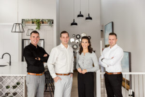 Top rated Airdrie Real Estate agents, Realty Aces team in modern Airdrie kitchen with members Ryan, Justin, Erica, and Damien.